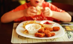 criança come fastfood